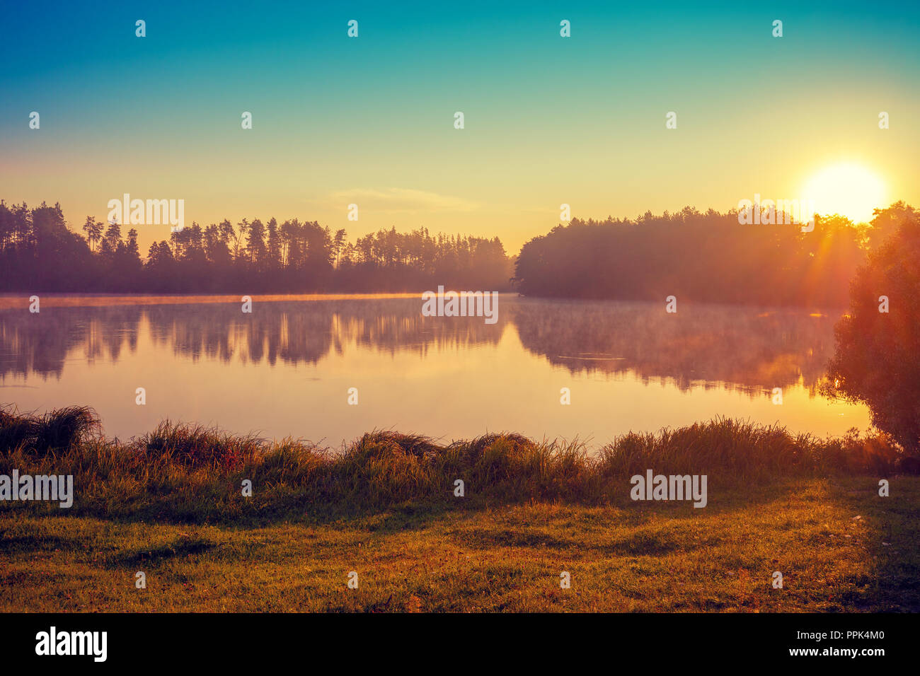 Früh am Morgen, Sonnenaufgang über dem See. Ländliche Landschaft. Schöne Natur Stockfoto