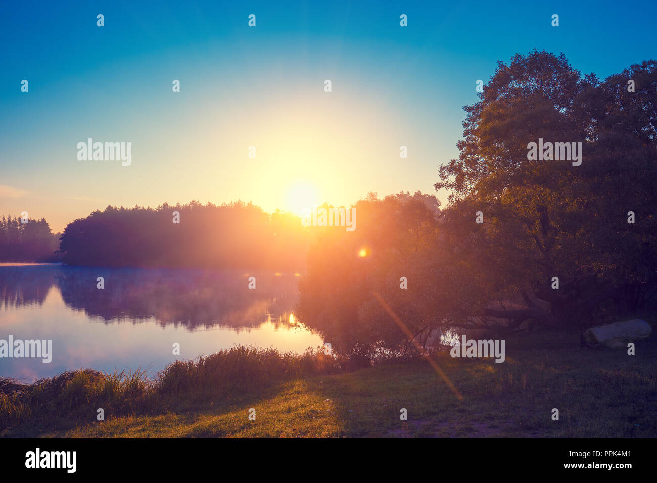 Früh am Morgen, Sonnenaufgang über dem See. Ländliche Landschaft. Schöne Natur Stockfoto