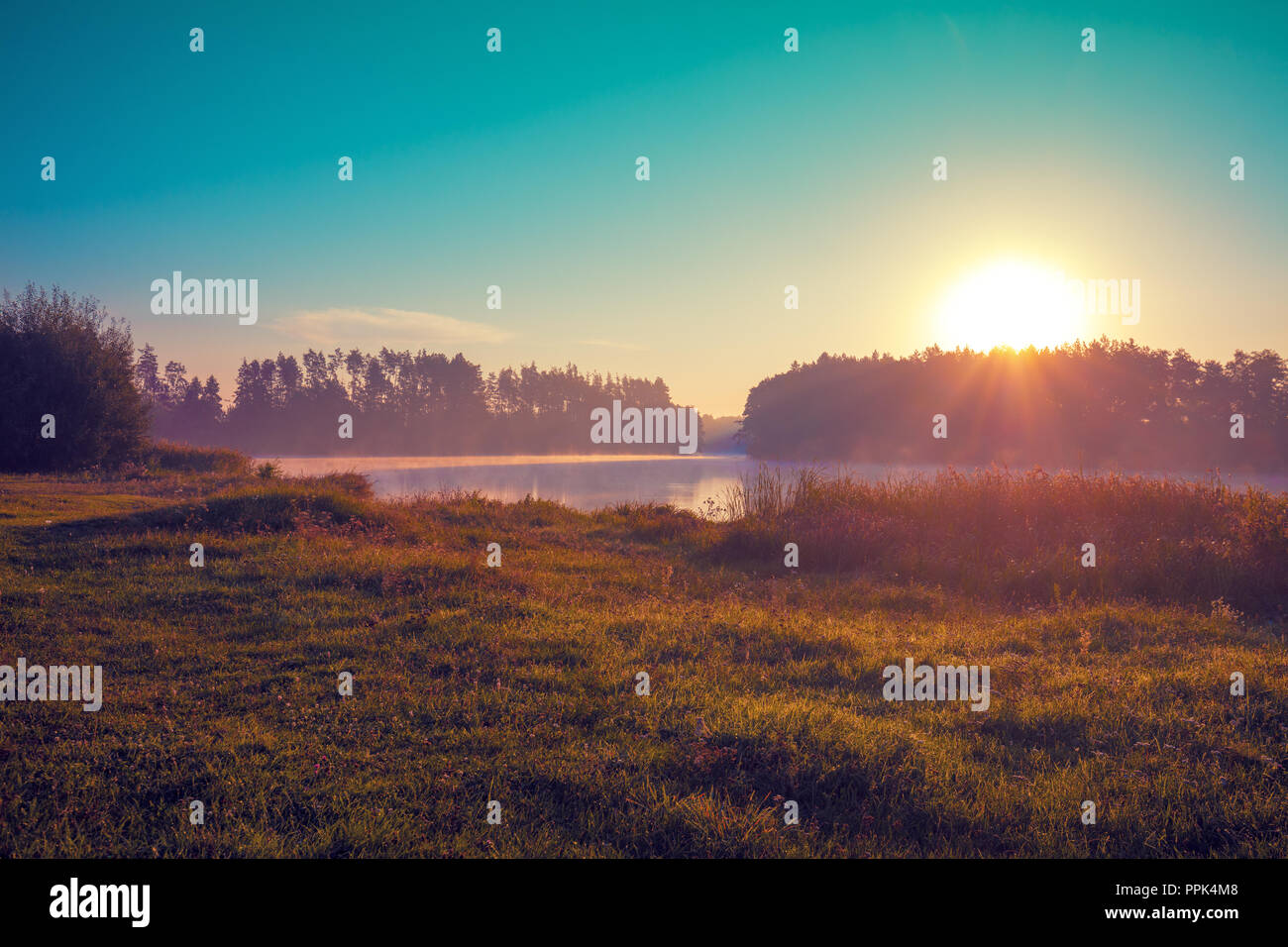 Früh am Morgen, Sonnenaufgang über dem See. Ländliche Landschaft. Schöne Natur Stockfoto