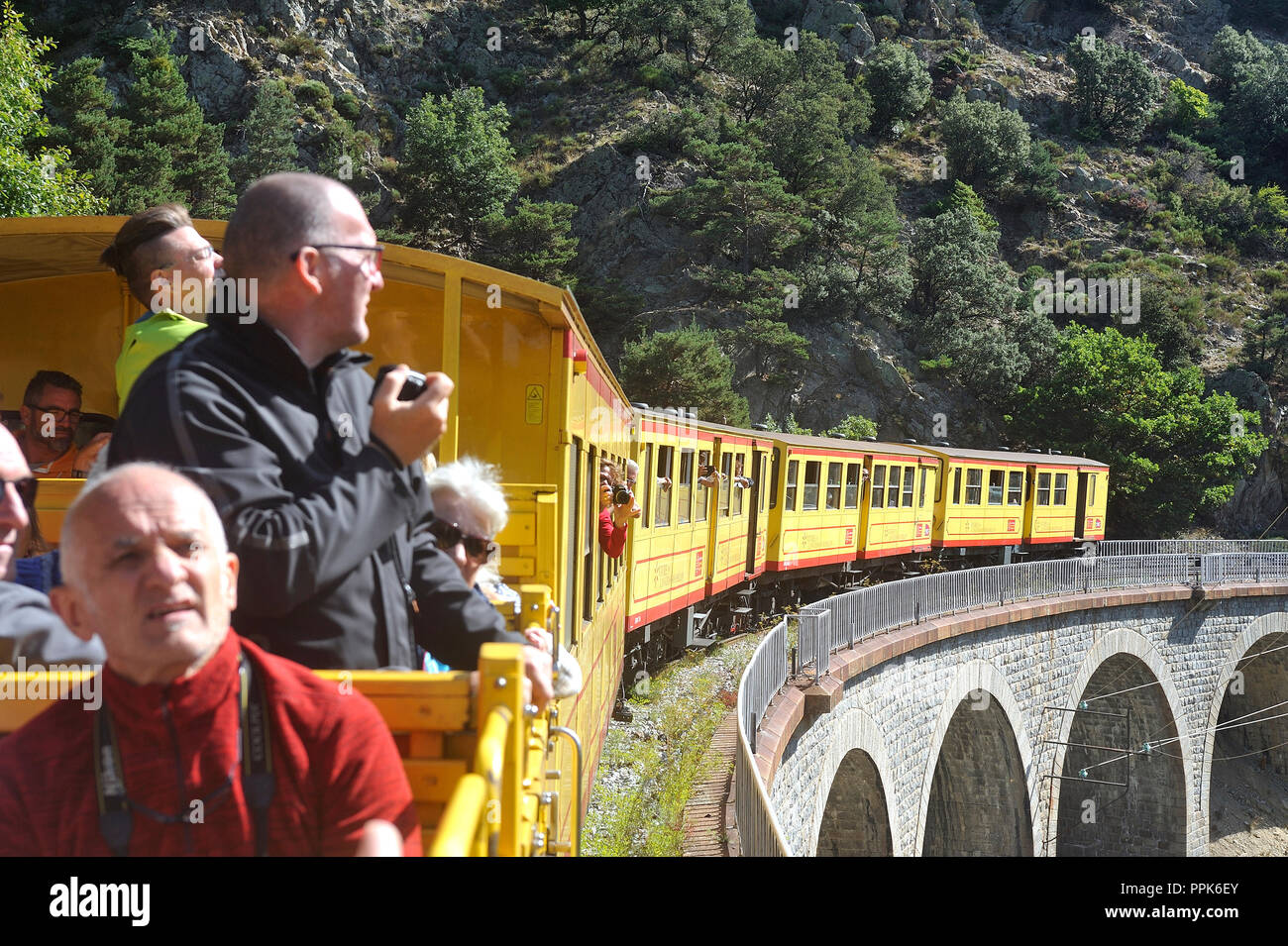 Die kleinen gelben Züge der Pyrenäen Überquerung einer wunderschönen Berglandschaft vorbei auf dem Viadukt Stockfoto