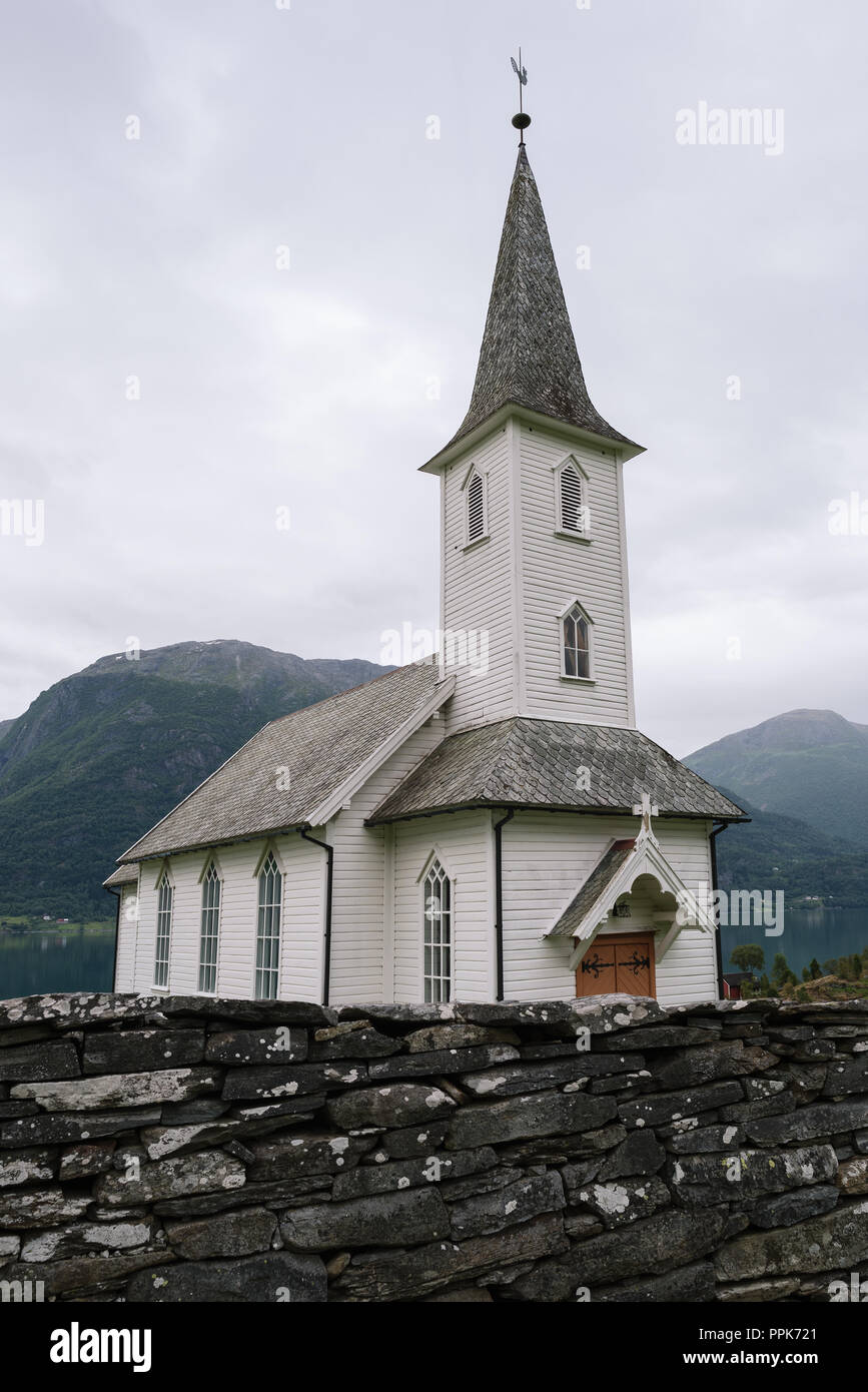 Nes kyrkje, Gemeinde Glanz, Norwegen. Weiße Holzkirche. Sommer bewölkt Landschaft Stockfoto