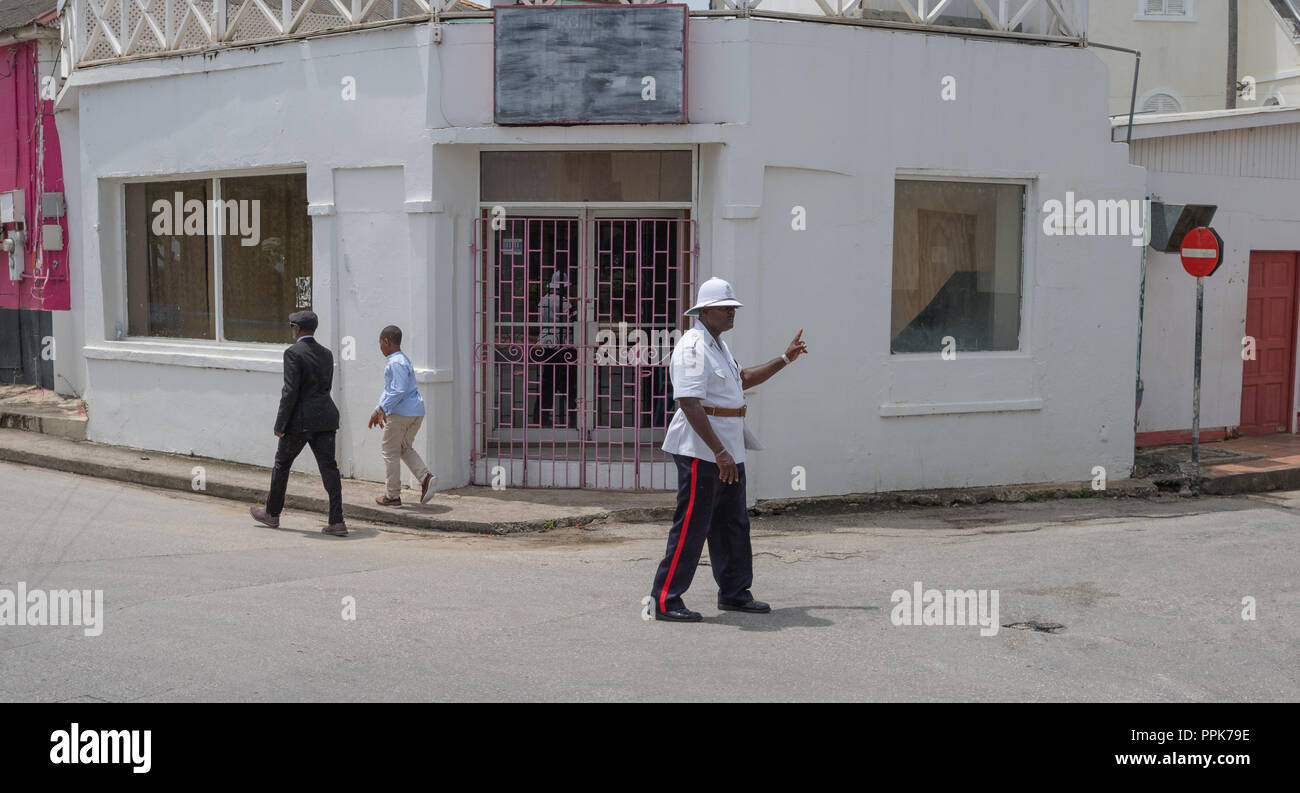 Polizeioffizier Regie Verkehr für einen der Polizisten Beerdigung auf der Ecke von der Queen Street und Church Street, St Francis Bay, Barbados Stockfoto