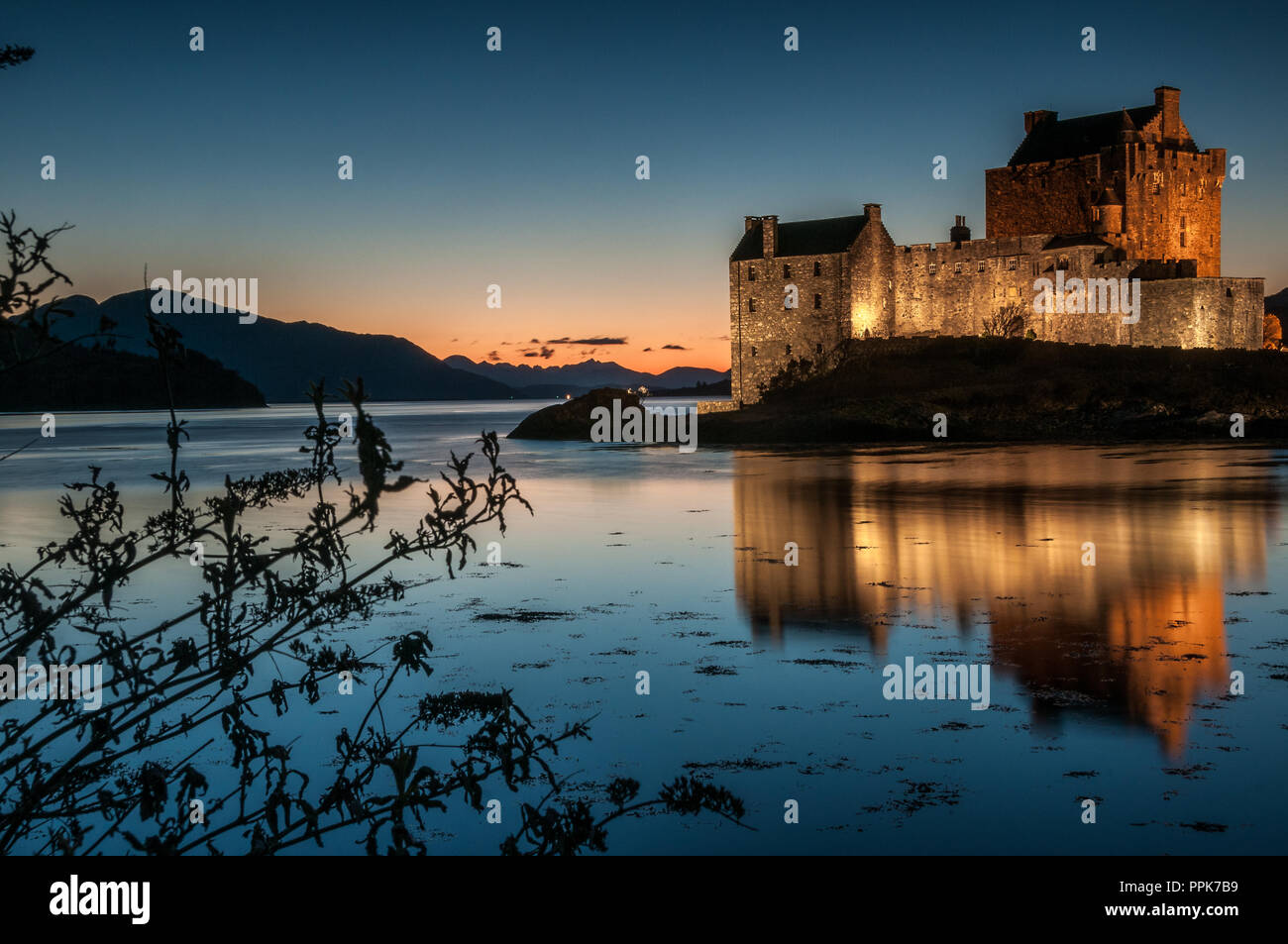 Die alten aus dem 13. Jahrhundert stammenden Schloss von Eilean Donan sitzen auf einer kleinen Insel im Loch Alsh bei Sonnenuntergang Stockfoto