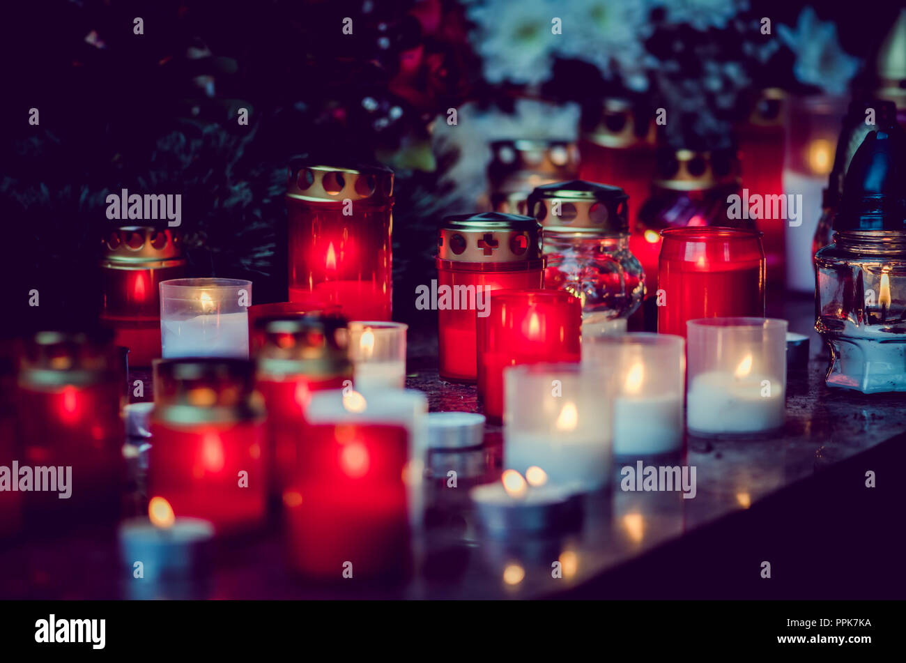 Bunte Kerzen während Allerheiligen auf dem Friedhof Stockfoto