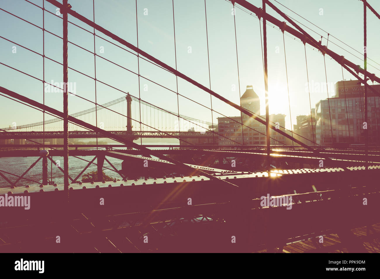 Vintage Farbe Blick auf die Brooklyn Bridge mit Details der Stahlträger und Unterstützung Kabel, Manhattan Skyline der Stadt bei Sonnenaufgang, New York City, New York, USA Stockfoto