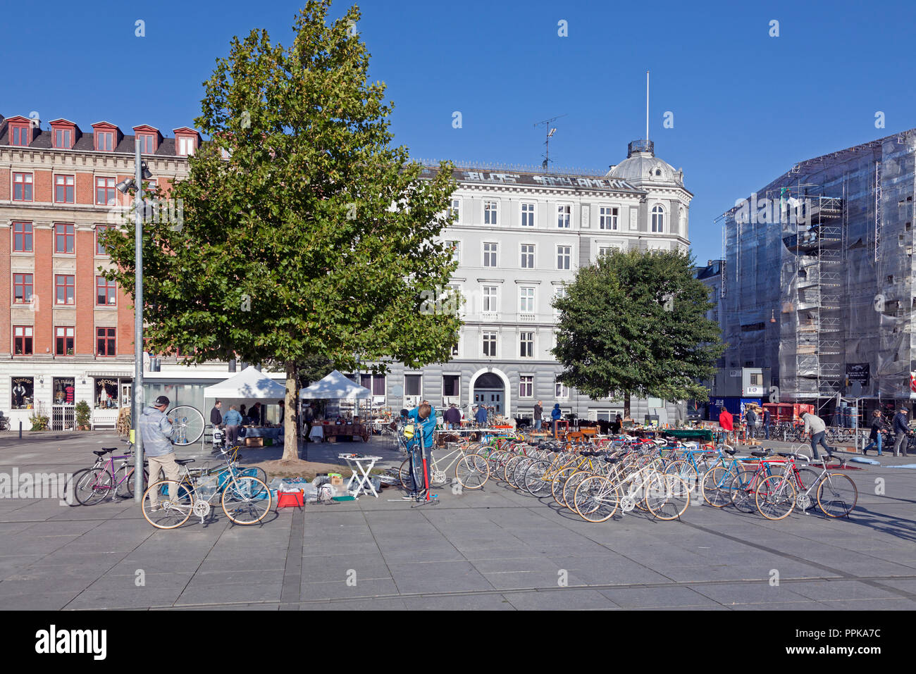Junge Fahrrad Mechanik Montage und Verkauf Fahrräder an einem Samstag Flohmarkt in Israels Plads, Israels Square, im sonnigen, herbstlichen Kopenhagen. Stockfoto