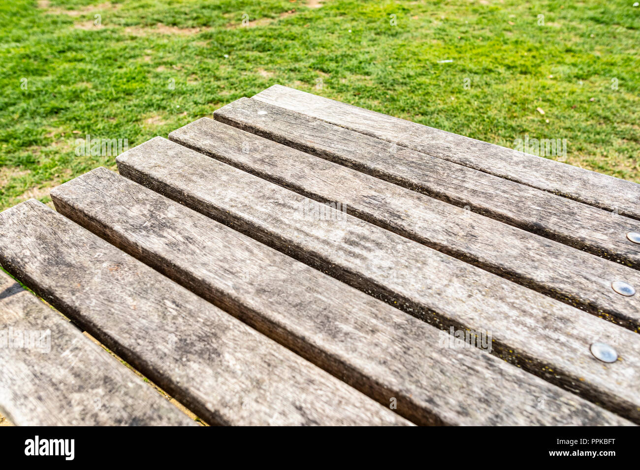 Nahaufnahme eines Outdoor vintage Holztisch mit Gras Hintergrund. Perfekt für Product Placement. Stockfoto