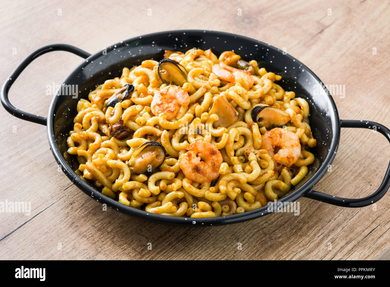 Traditionelle spanische fideua. Nudel Paella auf hölzernen Tisch. Nahaufnahme Stockfoto
