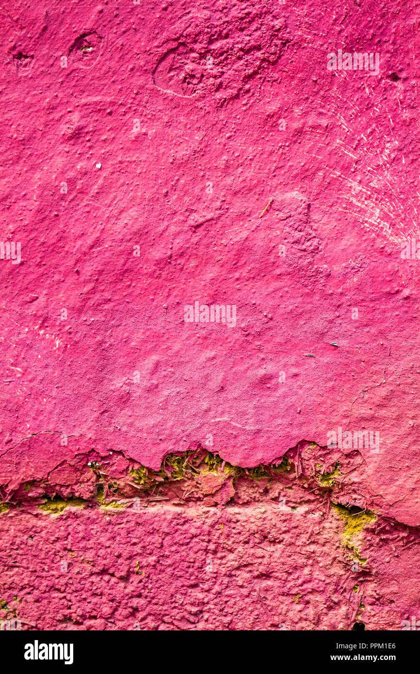 Alte, gesprungene Lehmziegelmauer mit Geschälten rosa Putz Stockfoto