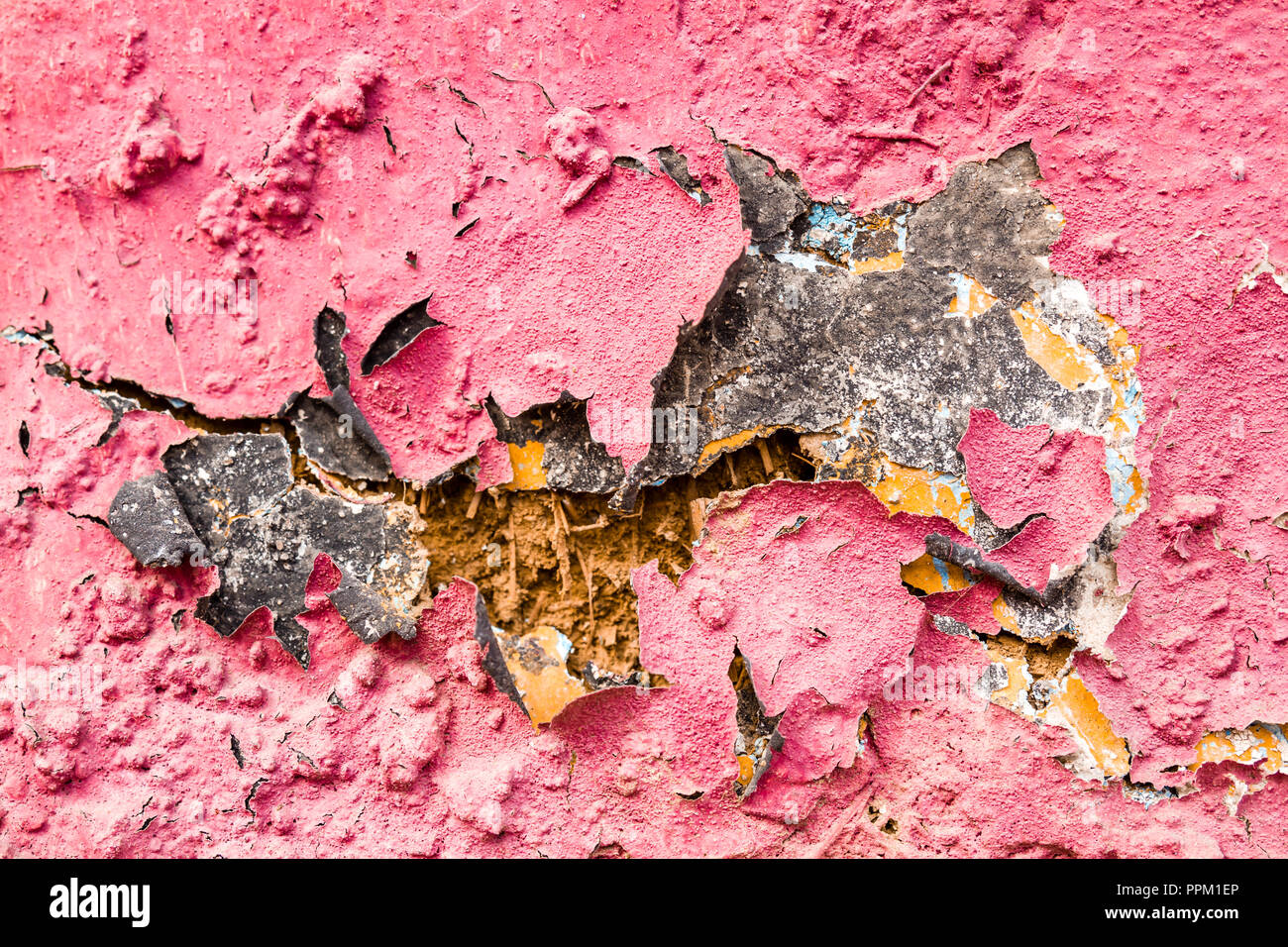 Alte, gesprungene Lehmziegelmauer mit Geschälten rosa Putz Stockfoto