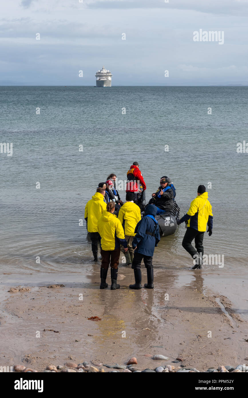 Passagiere, die aus "Die Welt" eine Unterkunft Schiff an Land setzen Sie an Claggain Bucht auf der Hebriden Insel Islay Stockfoto