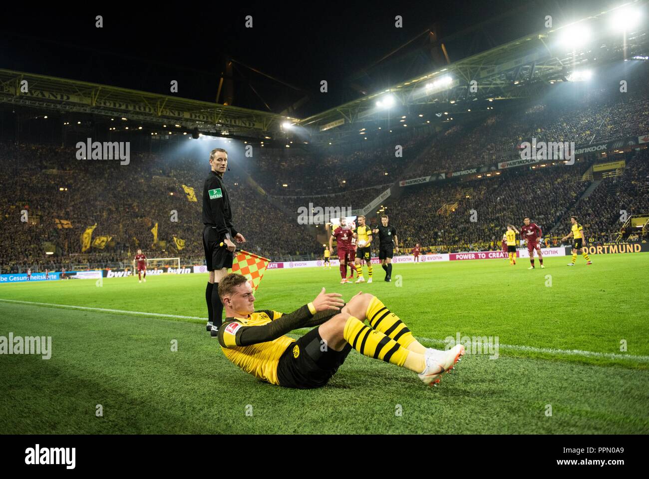 26. September 2018, Nordrhein-Westfalen, Dortmund: Fußball: Bundesliga, Borussia Dortmund - 1.FC Nürnberg, 5.Spieltag am Signal Iduna Park: Dortmunder Jakob Bruun Larsen sitzt auf dem Gras nach einem Duell. (EMBARGO BEDINGUNGEN - ACHTUNG: Der DFB verbietet die Nutzung und Veröffentlichung der sequenziellen Bilder auf das Internet und andere Onlinemedien während des Spiels (einschließlich der halben Zeit). Achtung: SPERRFRIST! Der DFB erlaubt die weitere Nutzung und Veröffentlichung der Bilder für mobile Dienste (insbesondere MMS) und für die erst nach dem Ende des Matches DVB-H und DMB.) Foto Stockfoto