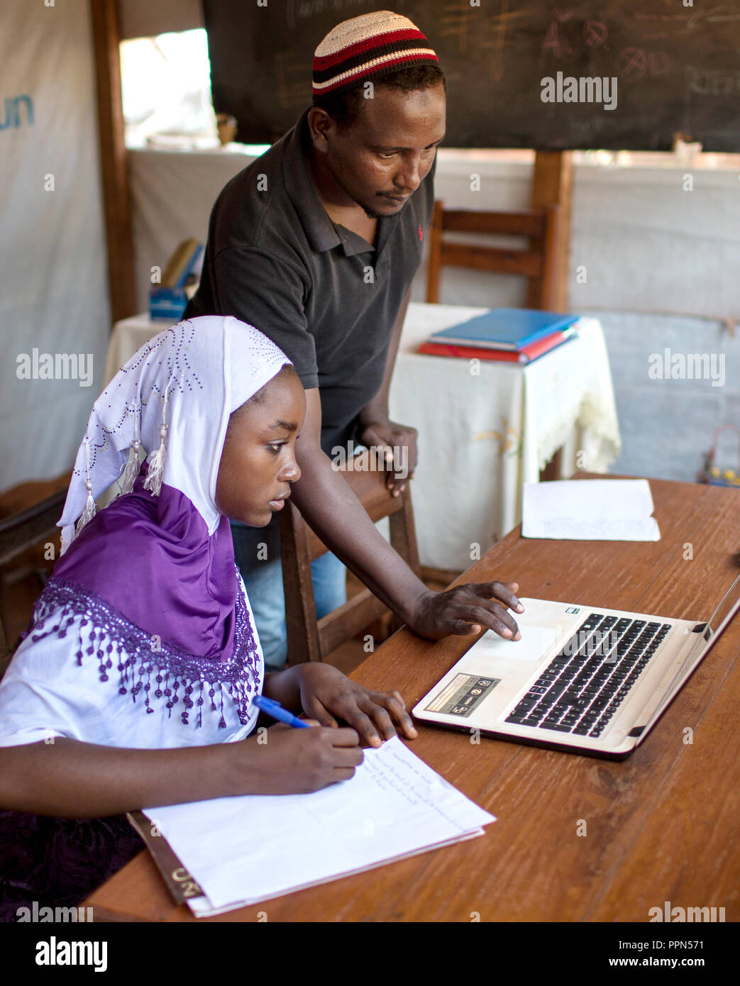 27. April 2018, Zentralafrikanische Republik, Bangassou: Djamaladine Mahamat Salet (stehend), ein 38-jähriger Informatiker lehre Oussna Abdraman (17) im Computer Lab, die er bei einer Siedlung für Intern Vertriebene auf dem Gelände der Bangassou Katholische Mission, Bangassou, Zentralafrikanische Republik, 28. April 2018 eröffnet. Salet, der auch verschoben wird, lehrt Vier zweistündige Sitzungen pro Tag, Montag bis Freitag mit 10 Schülern pro Klasse. Der Preis für den Kurs beträgt 10.000 CFA (ca. USD 19 $) für einen 3-monatigen Kurs. Foto: Baxter / wird Baxter/dpa Stockfoto