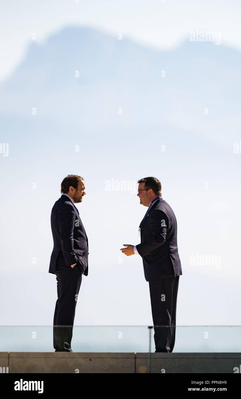 27. September 2018, Schweiz, Nyon: Samy Hamama (l, Berater des DFB-Präsident Grindl) und Stephan Osnabrügge (r), DFB-Schatzmeister, Plausch auf der Terrasse in der UEFA-Zentrale am Genfer See vor dem Hintergrund der Alpen. Die Entscheidung über den Austragungsort des nächsten aber eine kontinentale Turnier wird von den Mitgliedern des Exekutivkomitees der UEFA auf ihrer Tagung vom 27. September 2018. Die Fußball-Verbände aus Deutschland und der Türkei werden konkurrieren die 2024 Fußball-Europameisterschaft zu bewirten. Foto: Soeren Stache/dpa Stockfoto