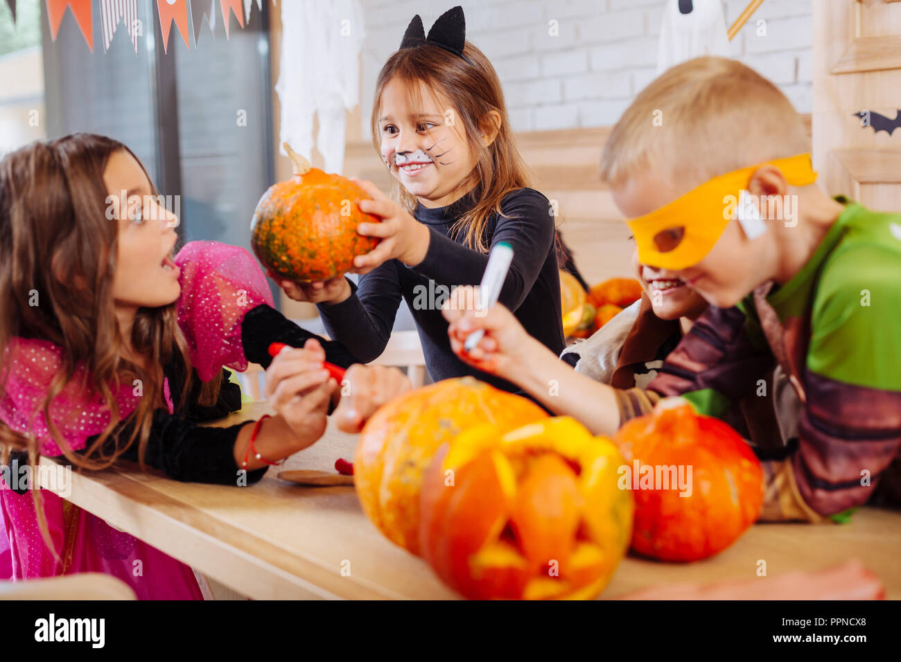 Niedlich mit lackierten cat face ihren Freunden Halloween Feiern erschrecken Stockfoto