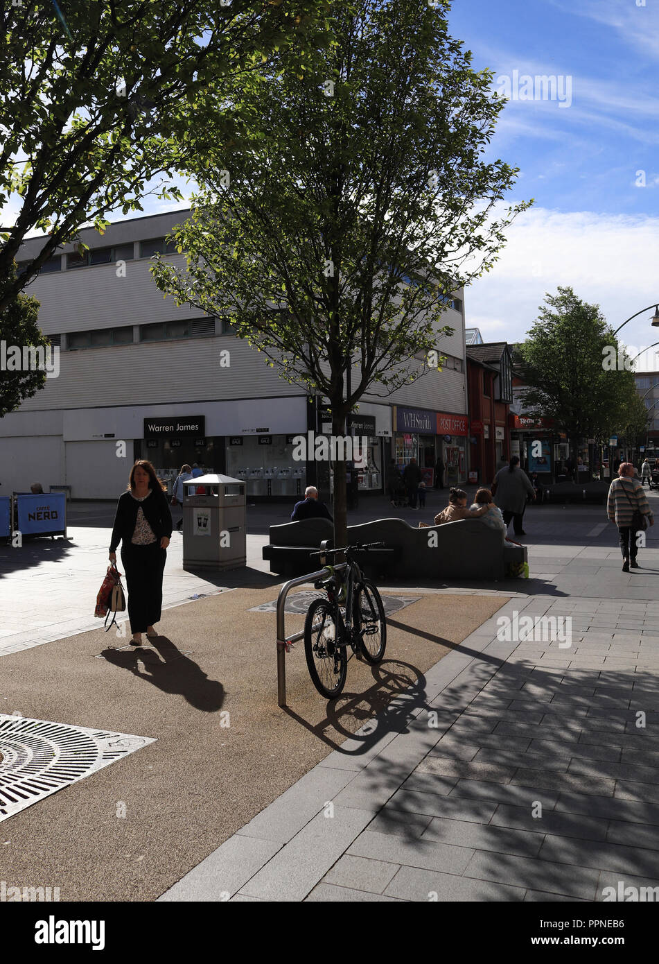 An einem hellen und sonnigen Herbst Tag blauer Himmel helfen starke Schatten, ein Fahrrad und ein Fußgänger auf der Chapel Street in der Küstenstadt Southport erstellen. Stockfoto