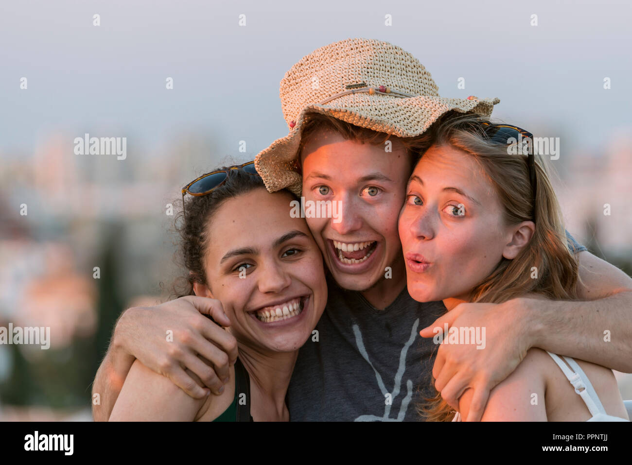 Zwei junge Frauen und ein junger Mann glücklich in die Kamera, Freunde suchen, Plaza de la Encarnacion, Sevilla, Andalusien, Spanien Stockfoto