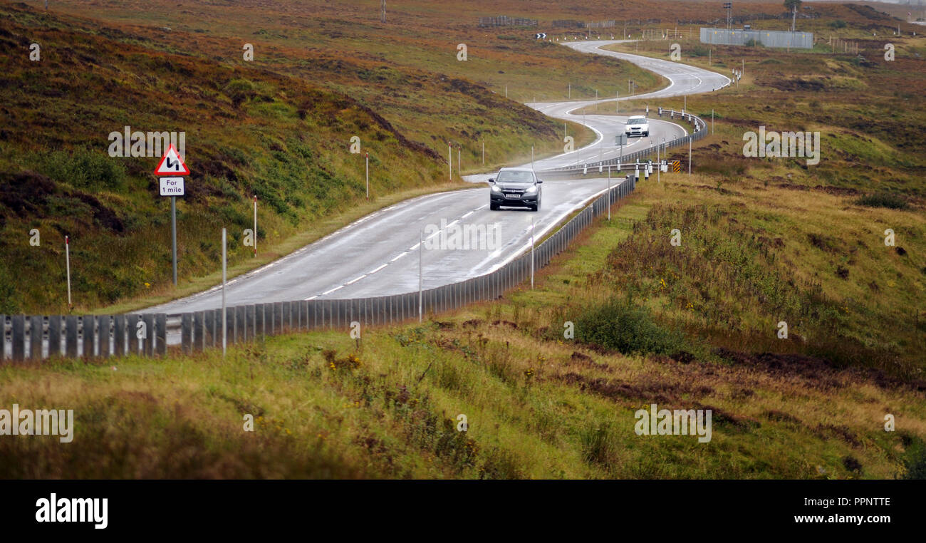 Autos fahren auf der A835 in der Nähe von ULLAPOOL SCHOTTLAND RE BIEGUNGEN IN DIE HIGHLANDS FAHREN an entfernten Standorten nassen Straßen schottischen UK Stockfoto