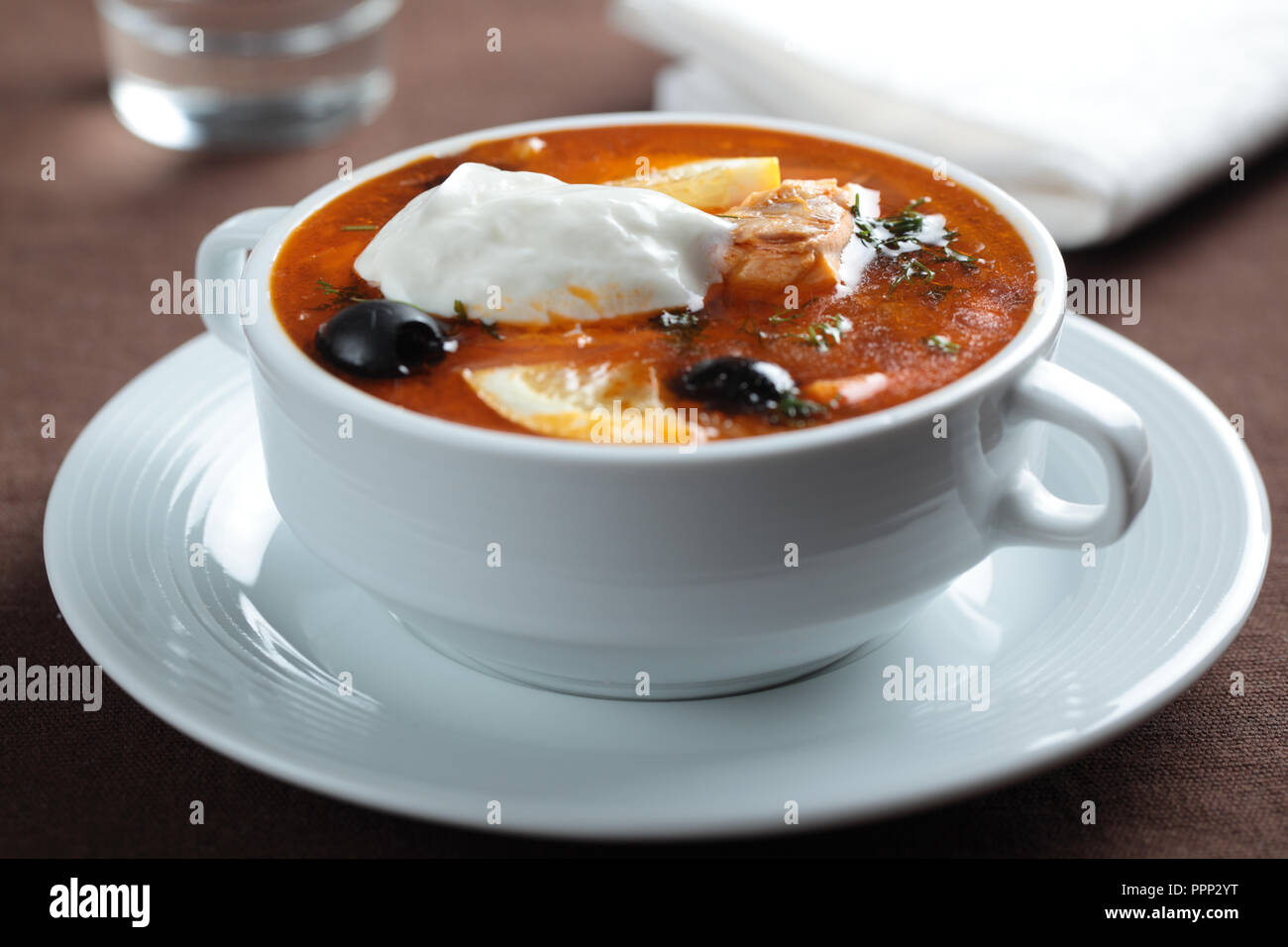 Solyanka, russische Suppe mit Lachs, Oliven und saure Sahne Stockfoto