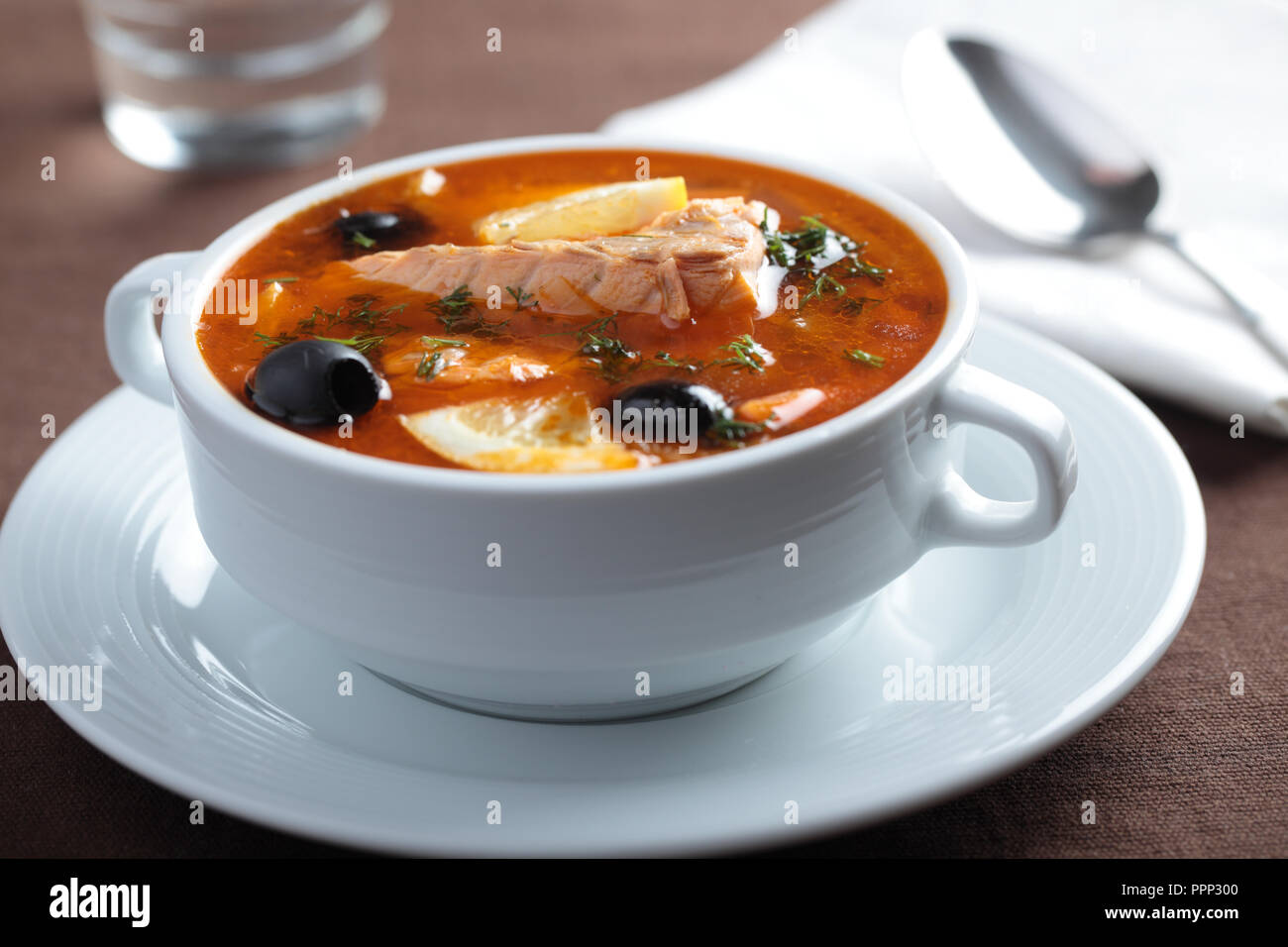 Solyanka, russische Suppe mit Lachs, Oliven und Zitronen Stockfoto