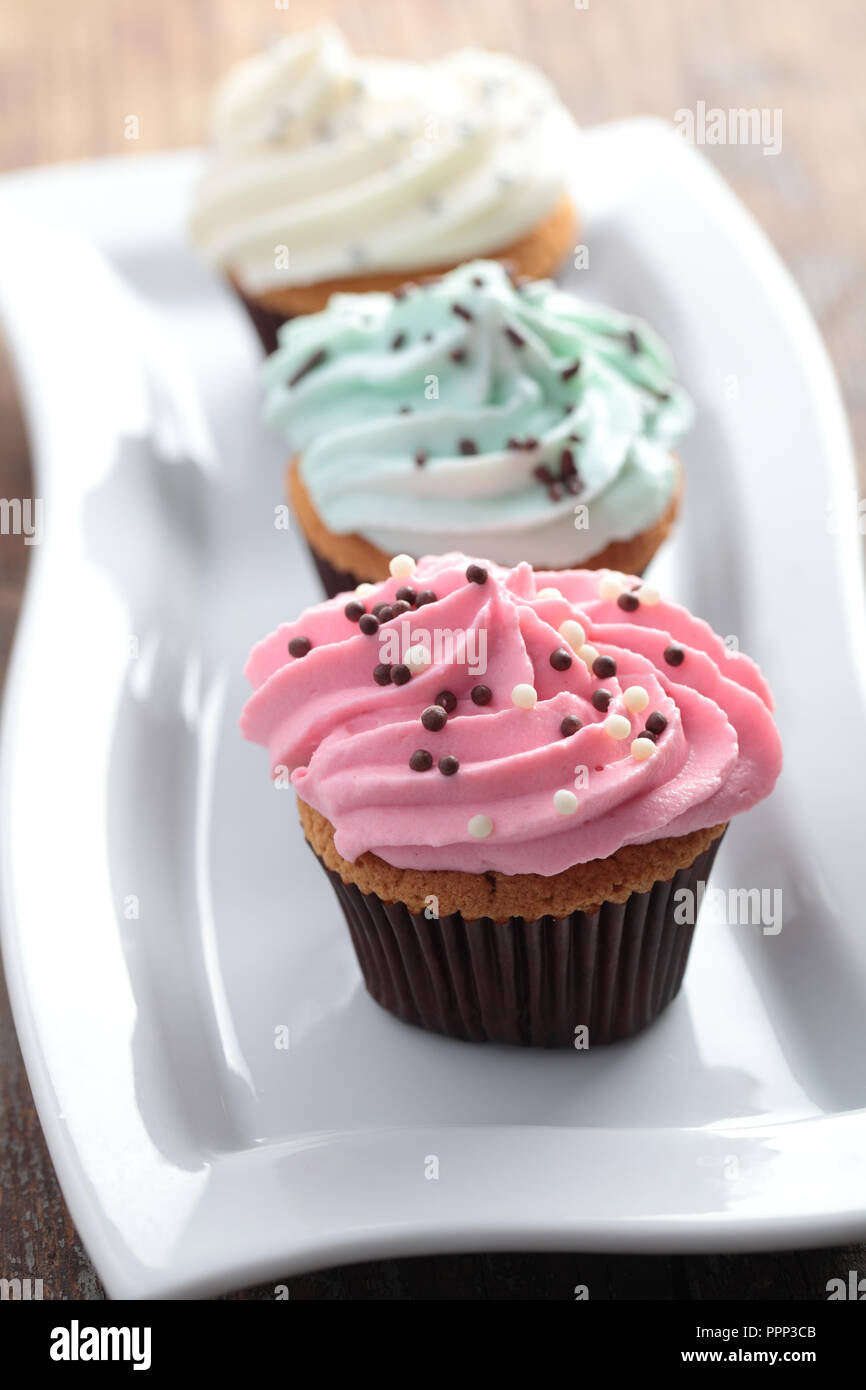 Cupcakes mit Zuckerglasur und Streuseln Stockfoto