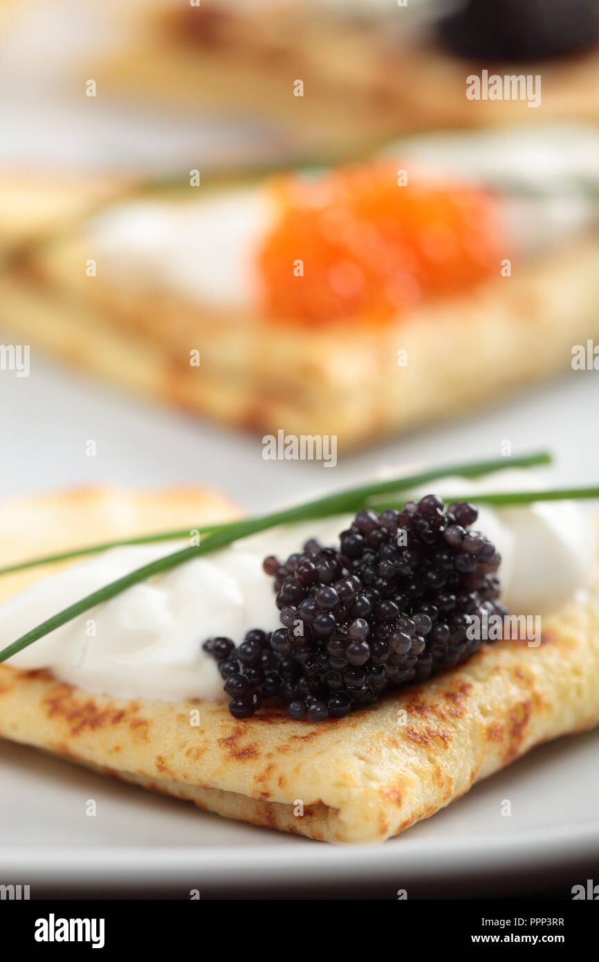 Crepes mit roter und schwarzer Kaviar auf einer Platte Stockfoto