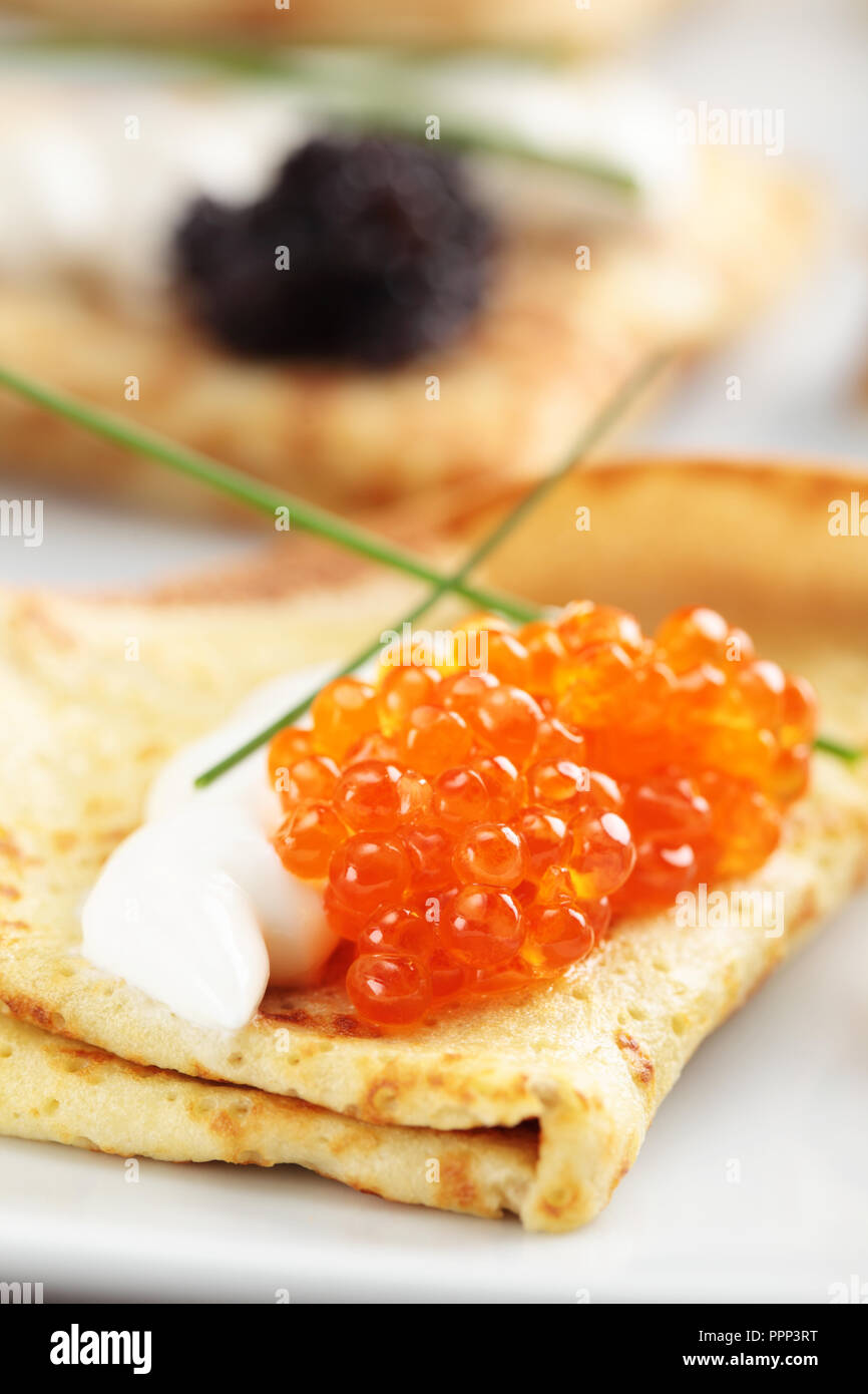 Crepes mit roter und schwarzer Kaviar auf einer Platte Stockfoto