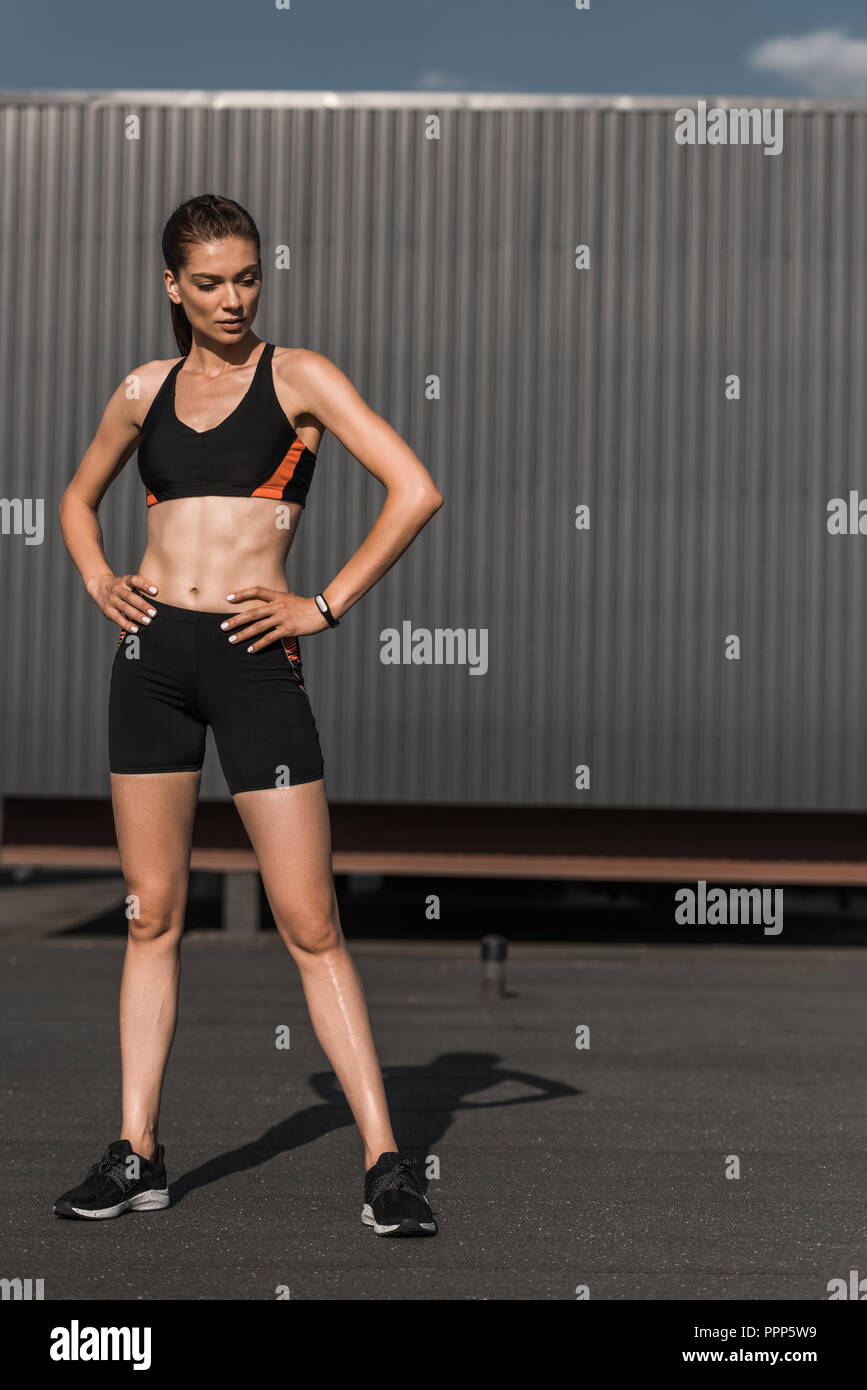 Junge athletische Frau mit Fitness Tracker in Sportkleidung posing Stockfoto