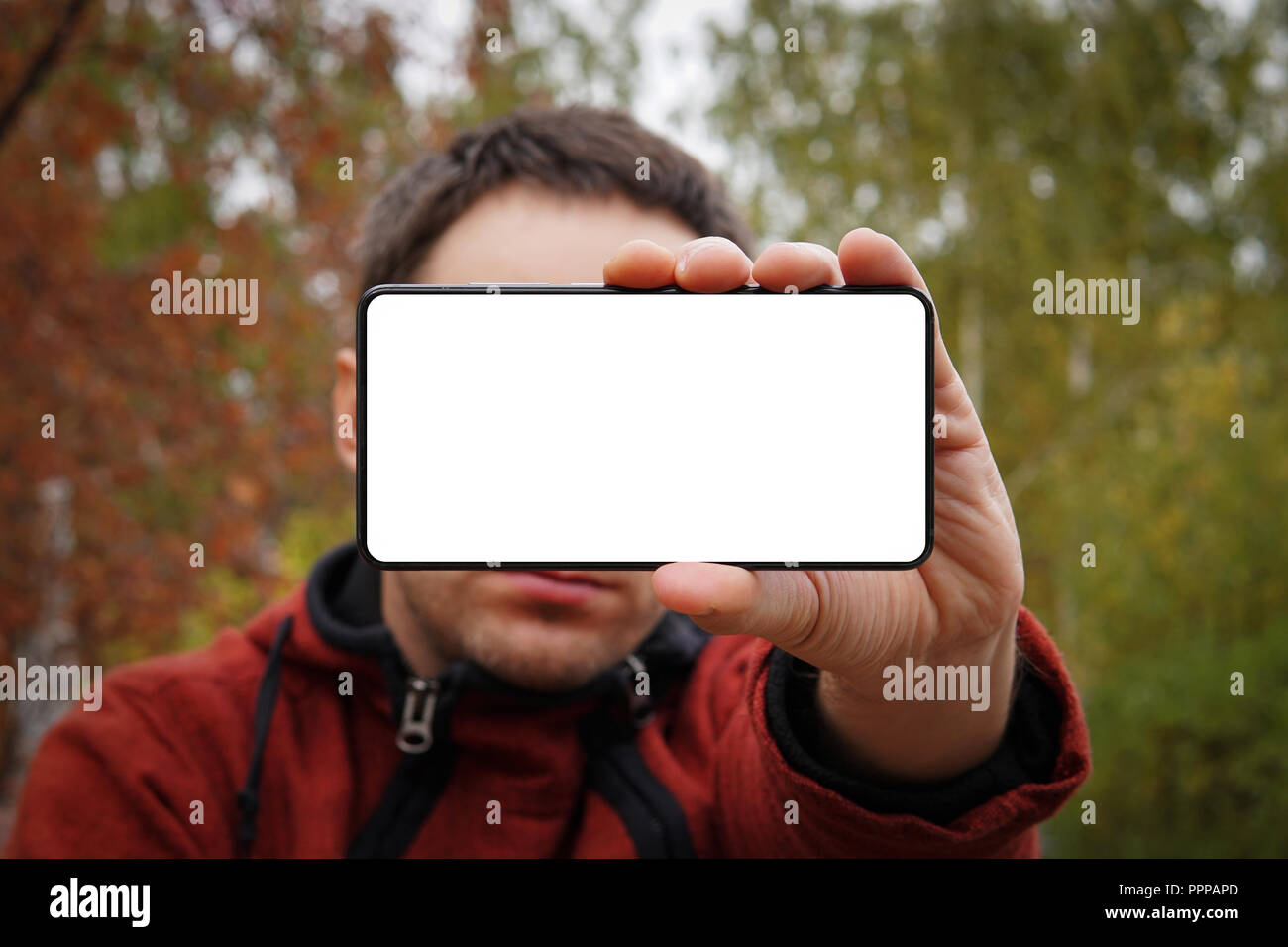 Nahaufnahme, junger Mann mit leerer Bildschirm Mobiltelefon über gelb grün Hintergrund. Weiß leerer Bildschirm für Design. mockup. Stockfoto