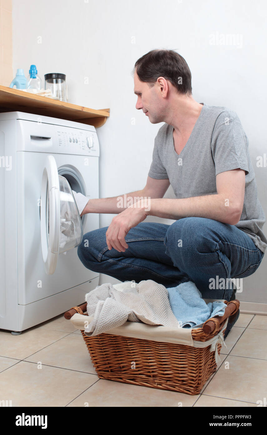 Man Kleidung laden in Waschmaschine Stockfoto