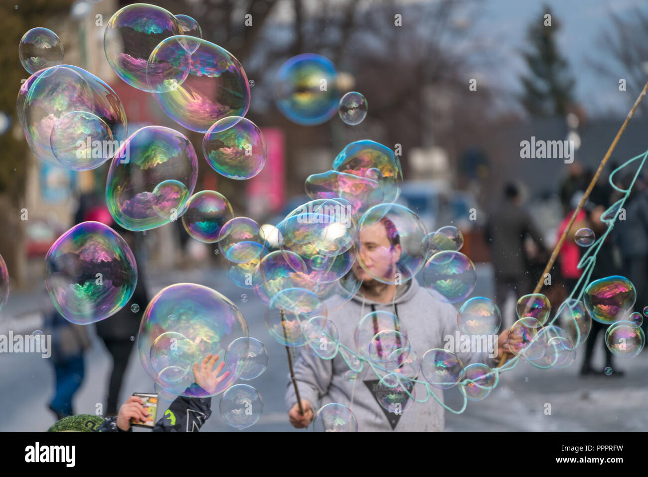 Karpacz, Polen - Februar 2018: Mann loslassen riesige Seifenblasen für Kinder und Jugendliche auf der Hauptstraße in Karpacz Stadt zu fangen, polnische Winter Ski re Stockfoto