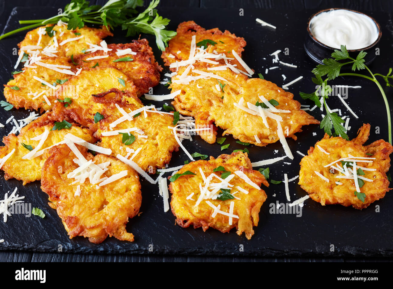 Schnelle Und Einfache Kurbis Krapfen Mit Geschredderten Italienischen Parmesan Und Petersilie Zu Machen Mit Saurer Sahne Sosse Serviert Auf Einem Schwarzen Brett Auf Einem Schwarzen Nicht Stockfotografie Alamy