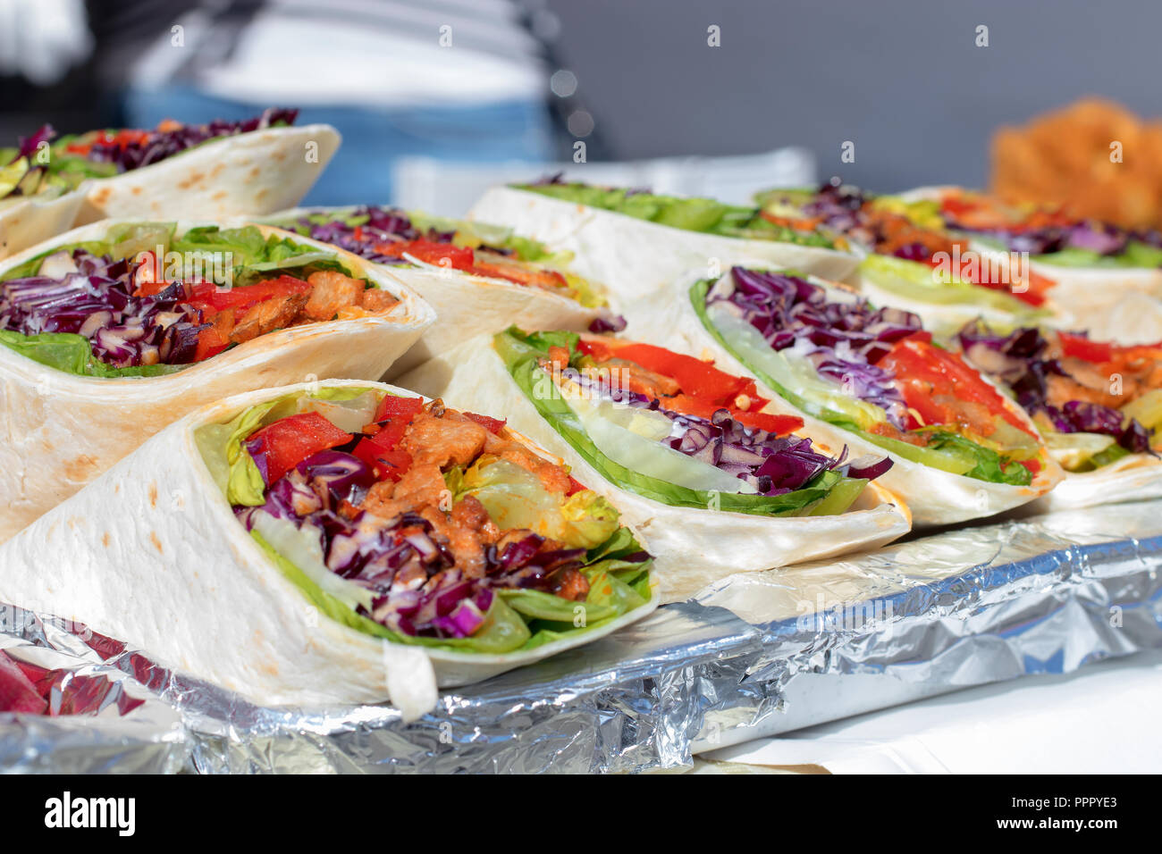 Wraps mit Fleisch und Gemüse, Kohl, Paprika, Tomaten und Kopfsalat. Metall Tablett mit Wraps, angezeigt Angebot für Besucher des Asiatischen Street Food m Stockfoto