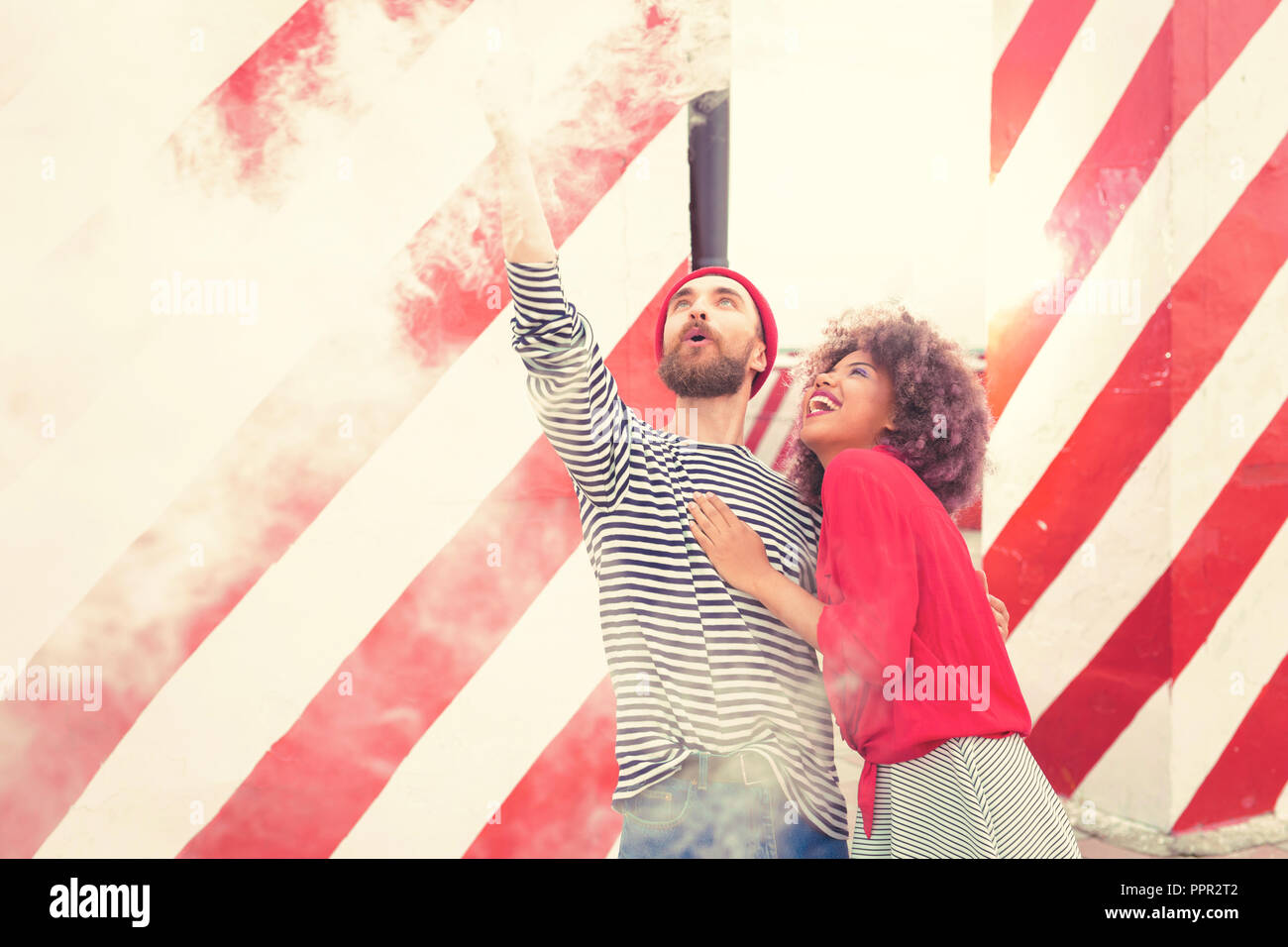 Emotionale Frau lachend, während ihr Freund holding Rauch flare Stockfoto