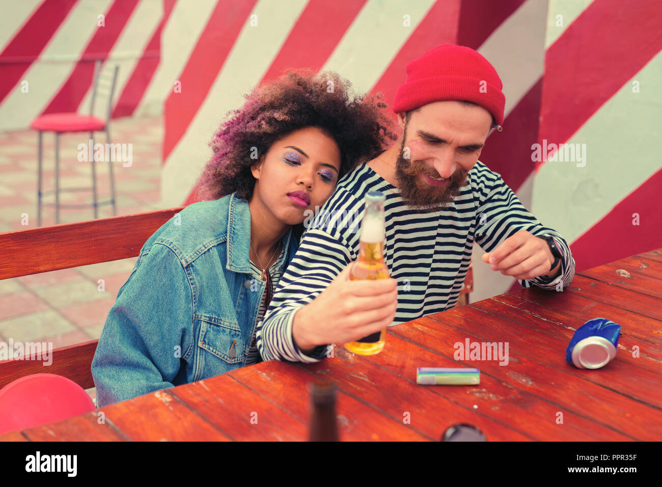 Bärtiger Mann lächelnd während, Flasche Bier nach der großen Party Stockfoto