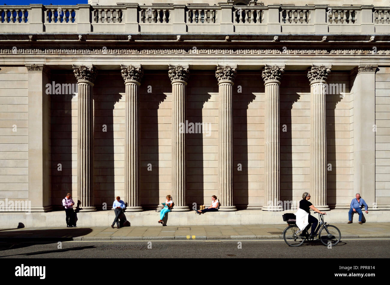 Leute sitzen auf der südlichen Fassade der Bank von England, London, England, UK. Stockfoto