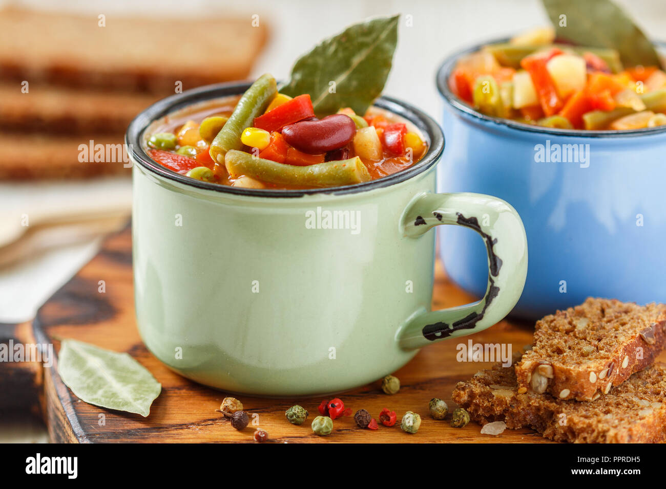 Eintopf - Deutsche traditionelle dicke Suppe mit Fleisch und Gemüse - Kartoffeln, Karotten, Zwiebeln, rote und grüne Bohnen, Mais und Tomaten mit Gewürzen ein Stockfoto