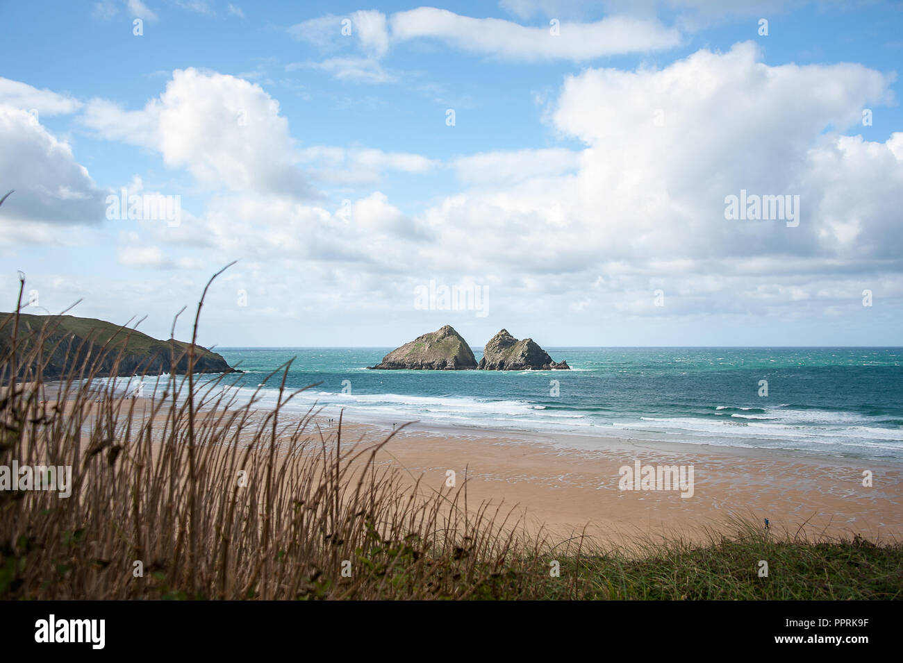 Möwe oder Carters von Felsen, Holywell Bay in der Nähe von Newquay, Cornwall. Küstenlandschaft mit Gras bedeckte Dünen, felsigen kleinen Inseln und blauen bewölkten Himmel Hintergrund. Stockfoto