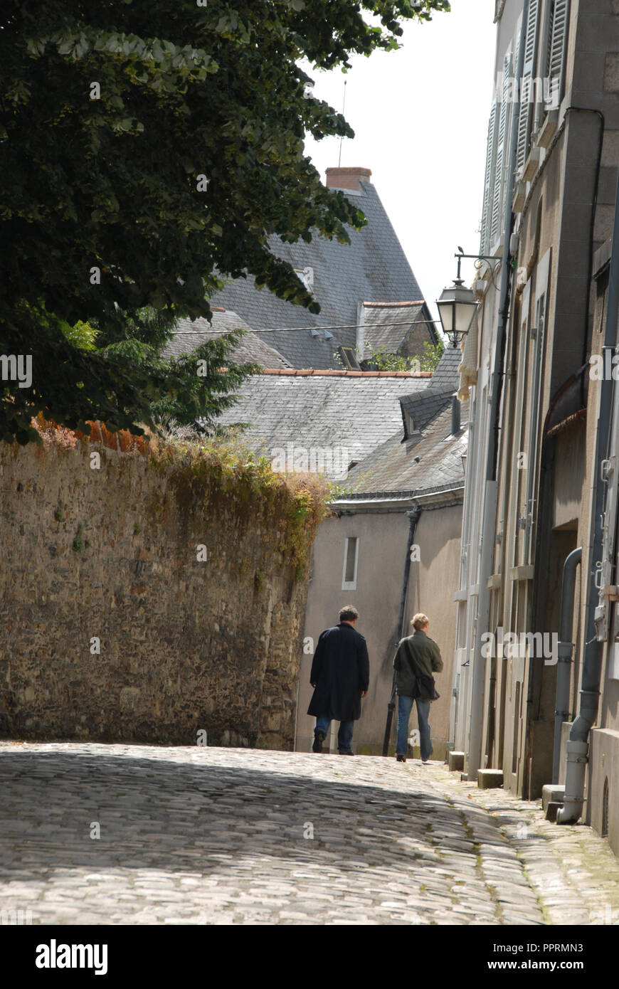 Besucher schlendern eine Kopfsteinpflasterstraße mit Häusern, die zu der Kathedrale Klerus in den alten Teil der Stadt von Angers, Val de Loire Loir (gesäumt Stockfoto