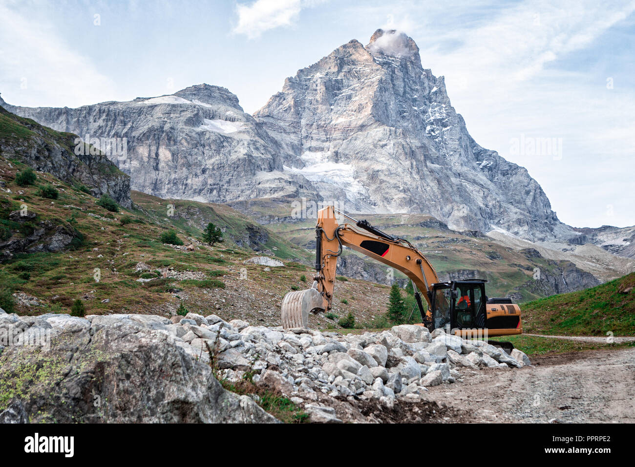 Bagger Bagger auf der Straße mit dem Berg im Hintergrund geparkt Stockfoto