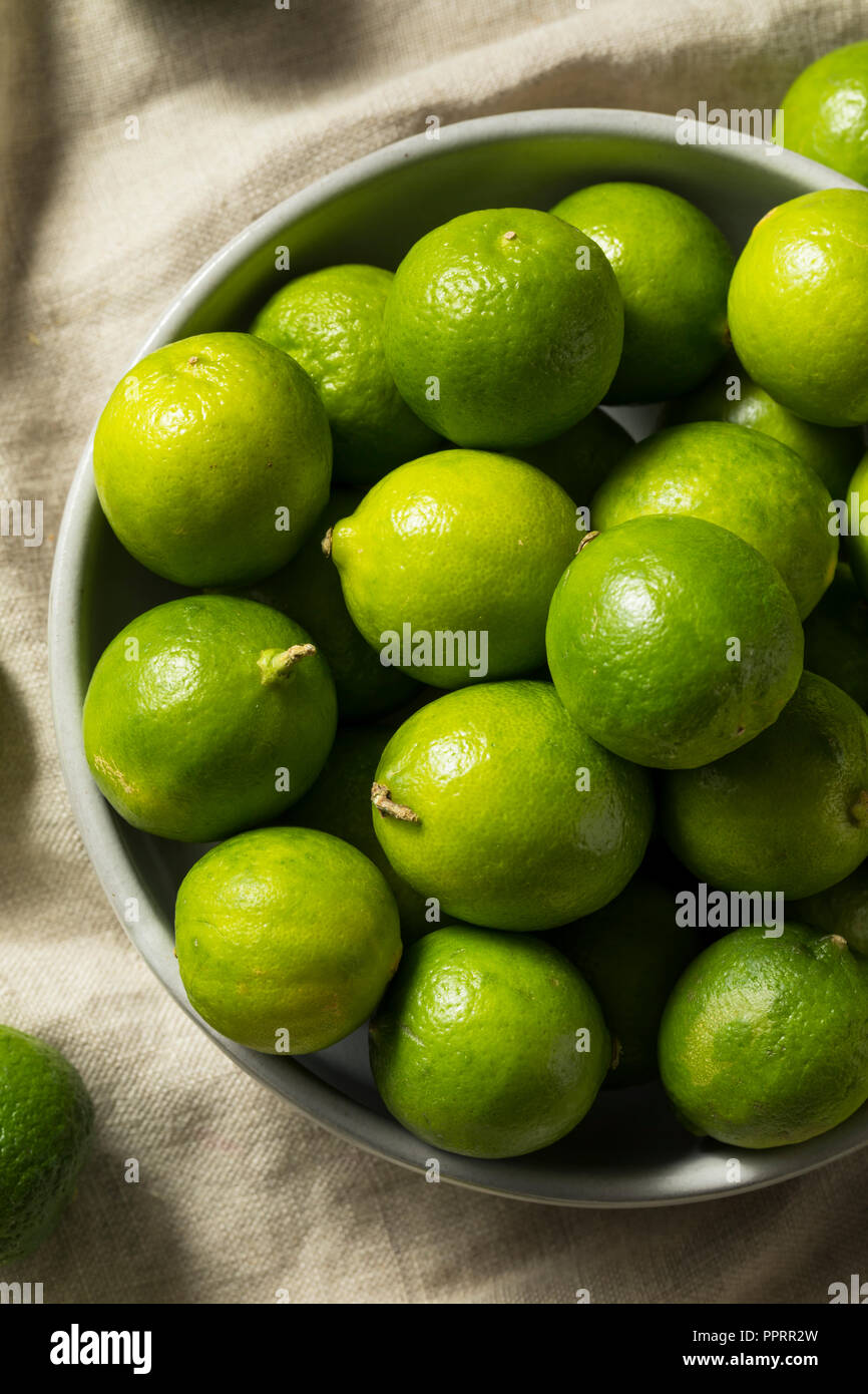 Rohe grüne Bio Key Limes in eine Schüssel geben Stockfoto