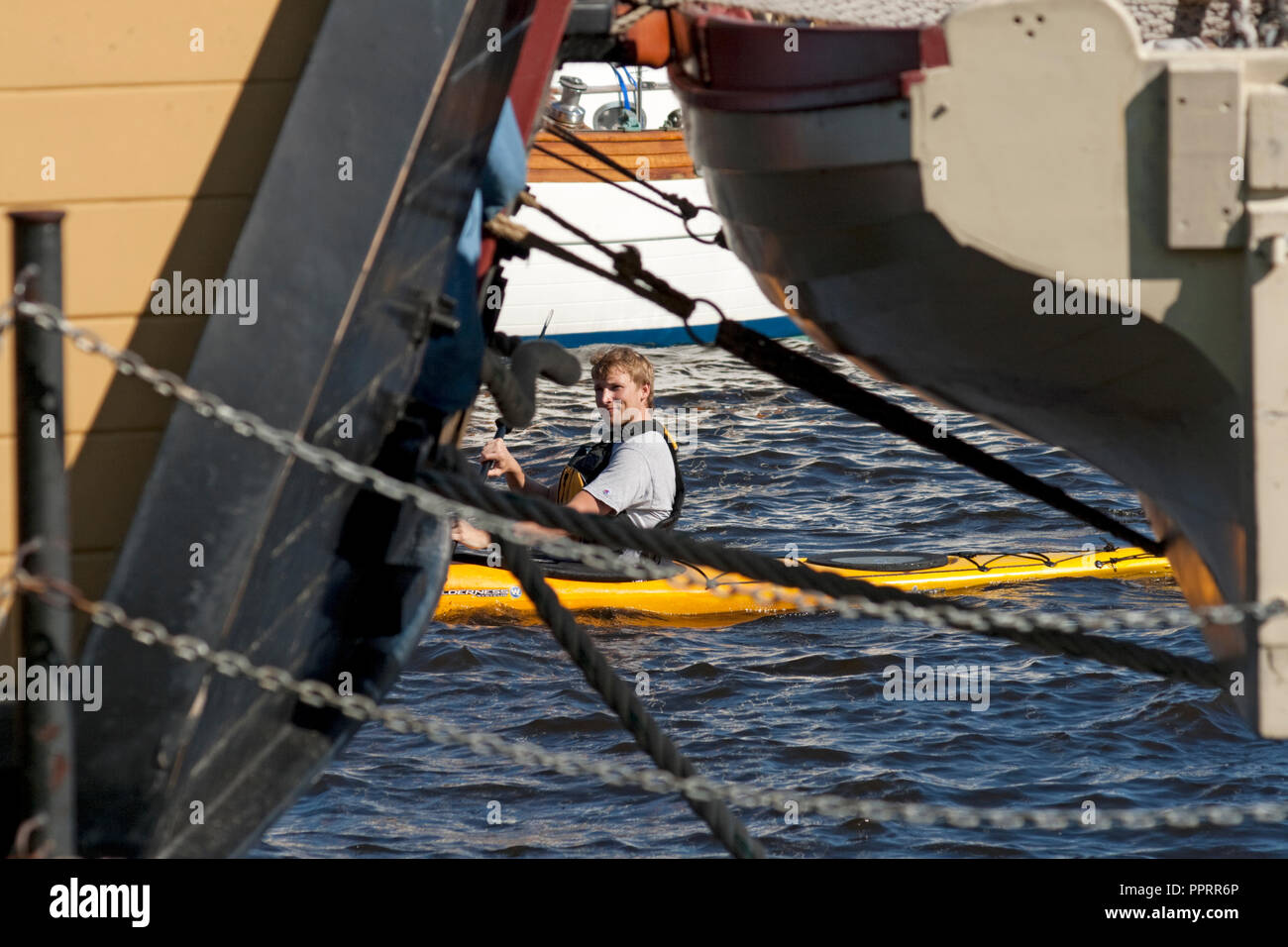 Man paddeln Kajak in der Duluth Lake Superior Harbour zwischen den Tall Ships im Maritime Festival. Duluth, Minnesota, MN USA Stockfoto