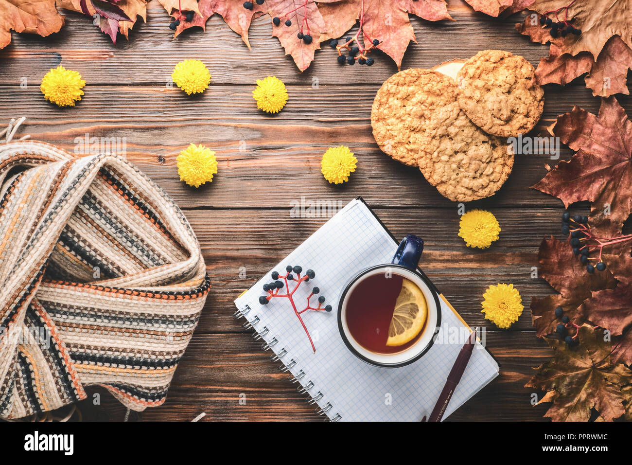 Herbst Mode saisonale Konzept skandinavischen Strickschal Tasse heißer schwarzer Tee, Kaffee, hausgemachten Haferflocken Cookies Fallen gefallen Ahornblätter auf hölzernen Tisch Stockfoto