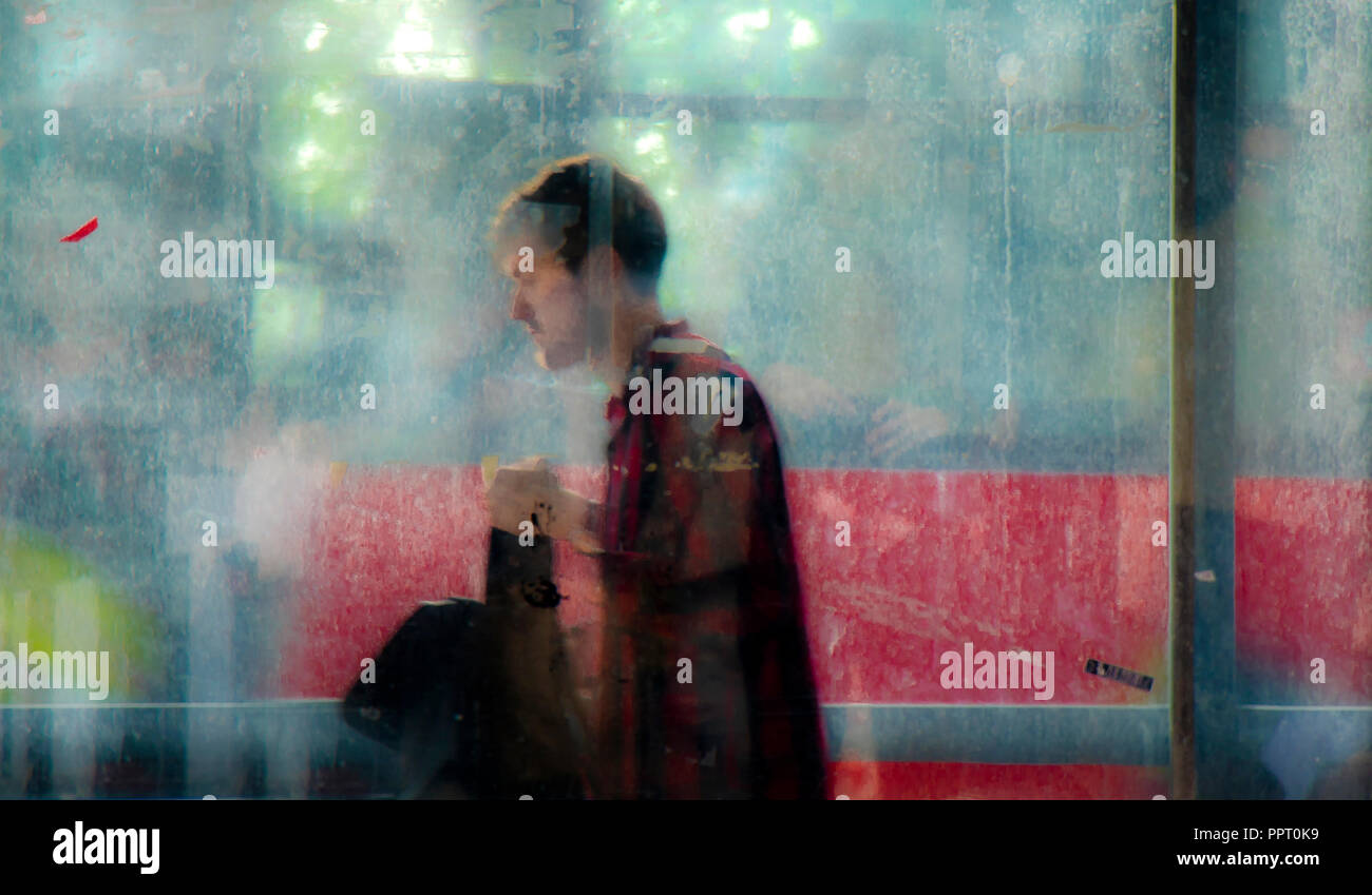 Belgrad, Serbien - 11. April 2018: Blurry jungen Mann zu Fuß von der U-Bahn Straße Passage und ein Verkehr hinter ihm, mit Reflexionen und bl Stockfoto