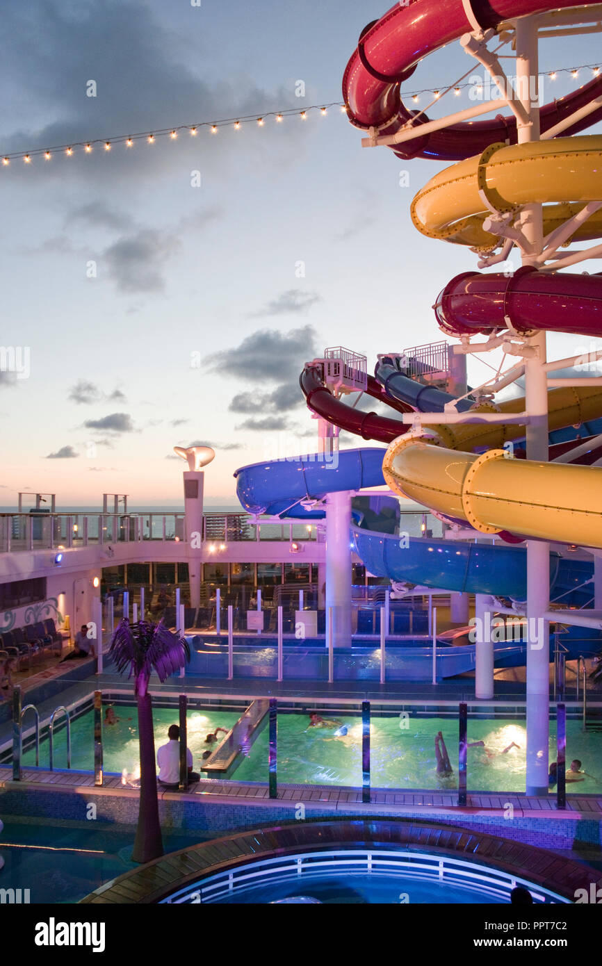 Eine Wasserrutsche und Pool auf dem obersten Deck eines Kreuzfahrtschiffes voyaging über den Atlantik nach Bermuda. Stockfoto