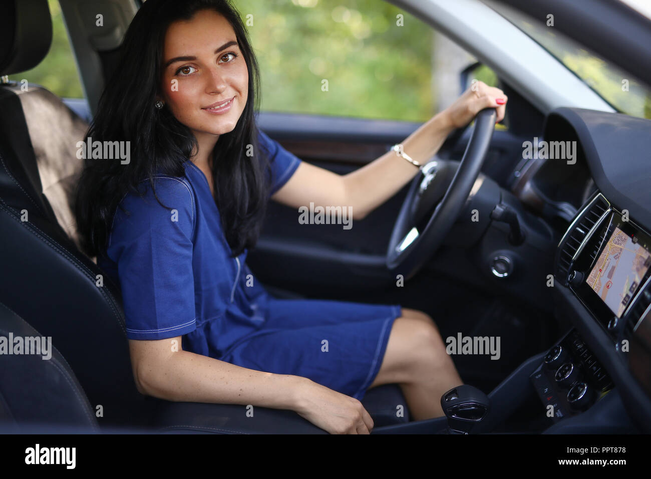 Die Frau auf dem Beifahrersitz durch das Lenkrad Stockfotografie