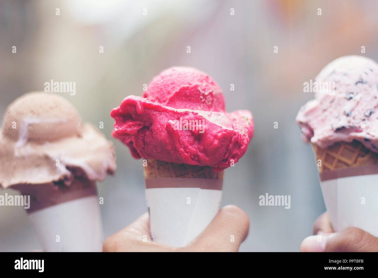 Woman's Hände, die schmelzenden Eis Waffel Kegel in die Hände auf Sommer Licht Stockfoto
