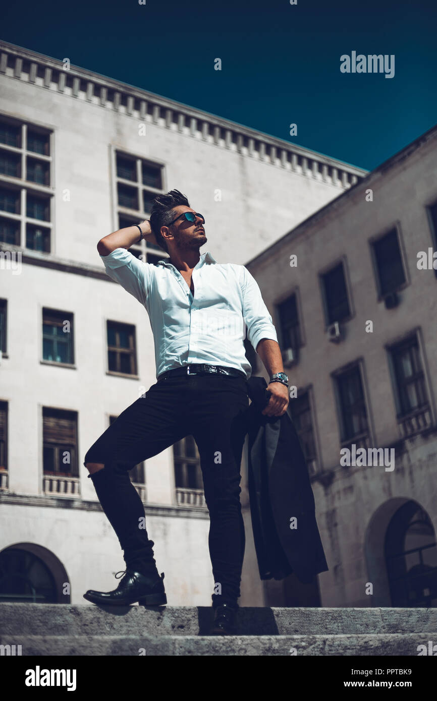 Porträt eines erfolgreichen jungen Geschäftsmann in Anzug gekleidet zu Fuß die Treppe hinunter. Konzept Modische junge Mann Stockfoto