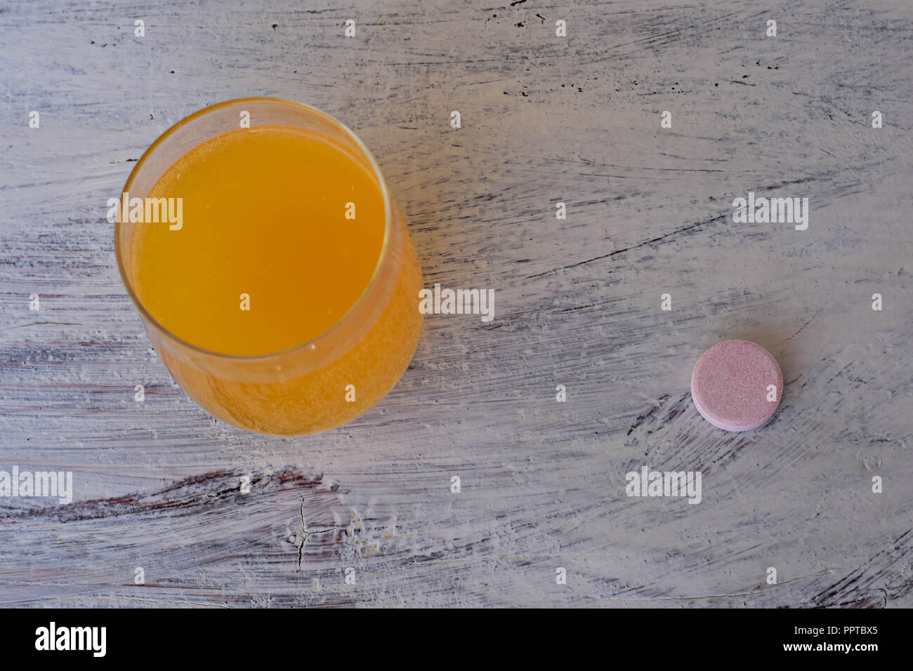 Brausetablette auf weißem Hintergrund mit orangefarbenen Brausetabletten blasen von Kalzium und Vitamin C Brausetabletten in transparentem Glas. Vitamine, Stockfoto