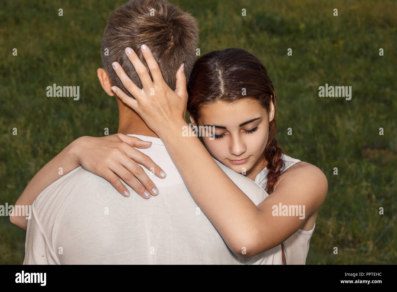 Schöne junge Mädchen umarmt einen Kerl in der Natur. Stockfoto